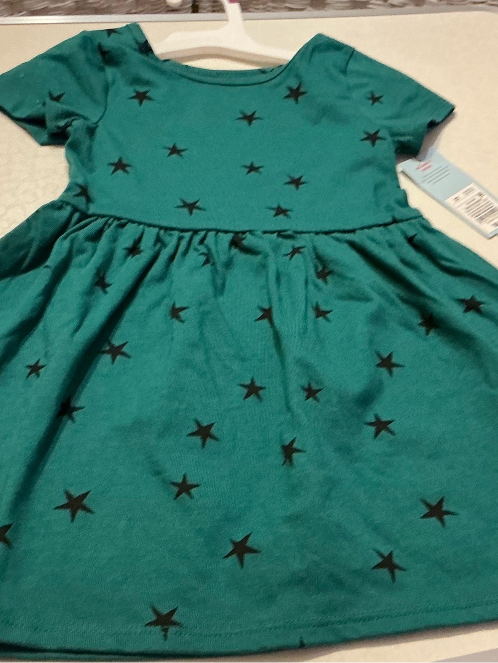 Size 4T dresses paired. A dark green & black starred dress & sage colored